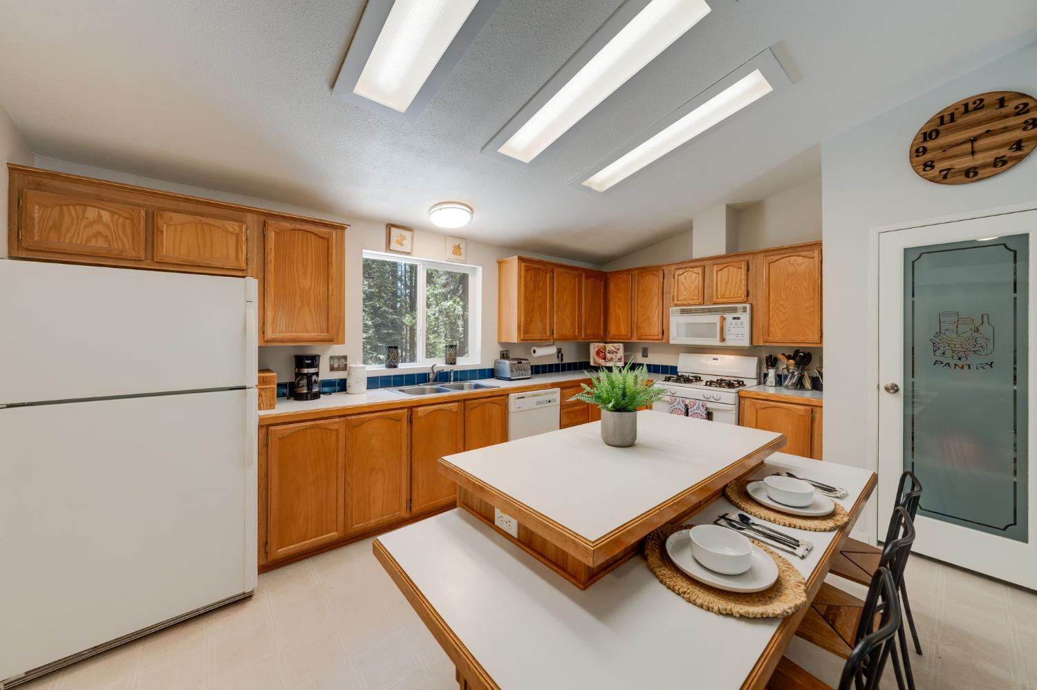 28722 Wood Road Pioneer, CA 95666 - Photo 14 of 39 a kitchen with a refrigerator a stove top oven a sink dishwasher and white appliances with wooden floor