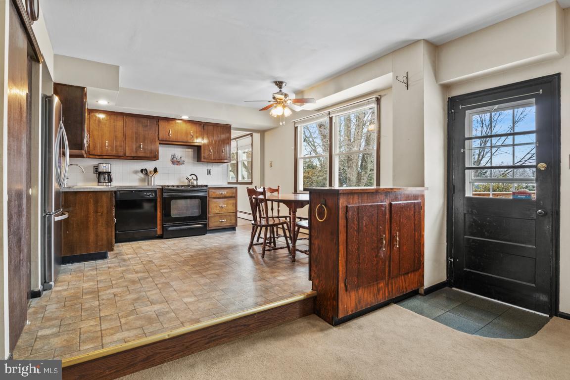 29 Holly Hill Road Richboro, PA 18954 - Photo 15 of 40 a kitchen with stainless steel appliances granite countertop a stove top oven a refrigerator a dining table and chairs with wooden floor