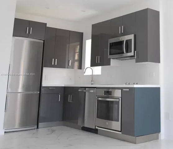 a kitchen with stainless steel appliances granite countertop a refrigerator and a stove