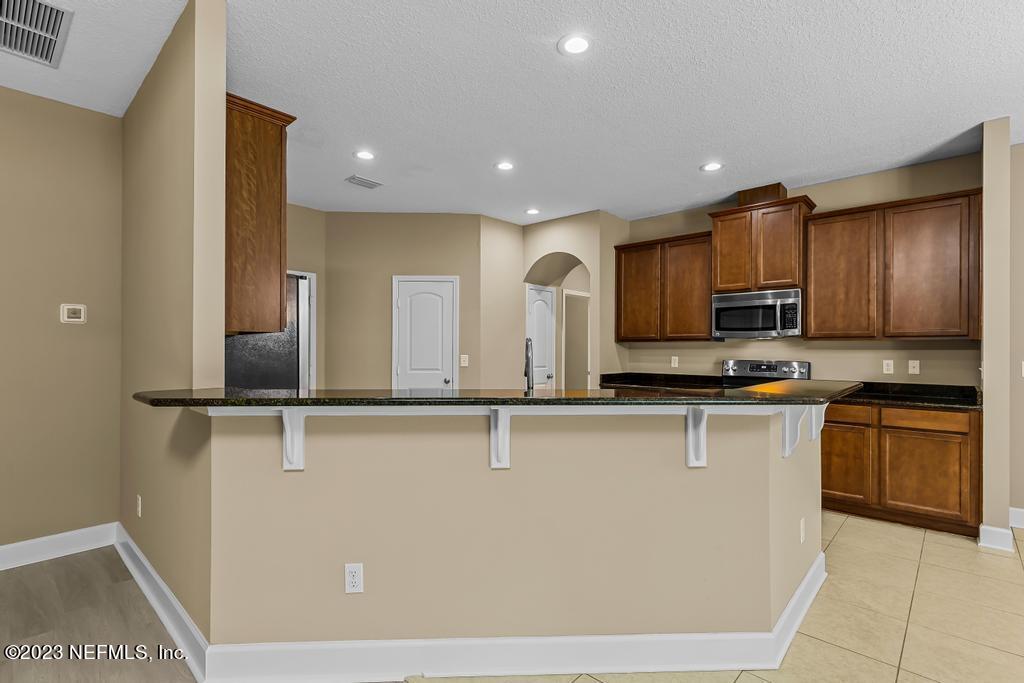 126 Arabian Court St. Augustine, FL 32095 - Photo 11 of 62 a kitchen with stainless steel appliances granite countertop a sink a stove top oven and granite counter tops