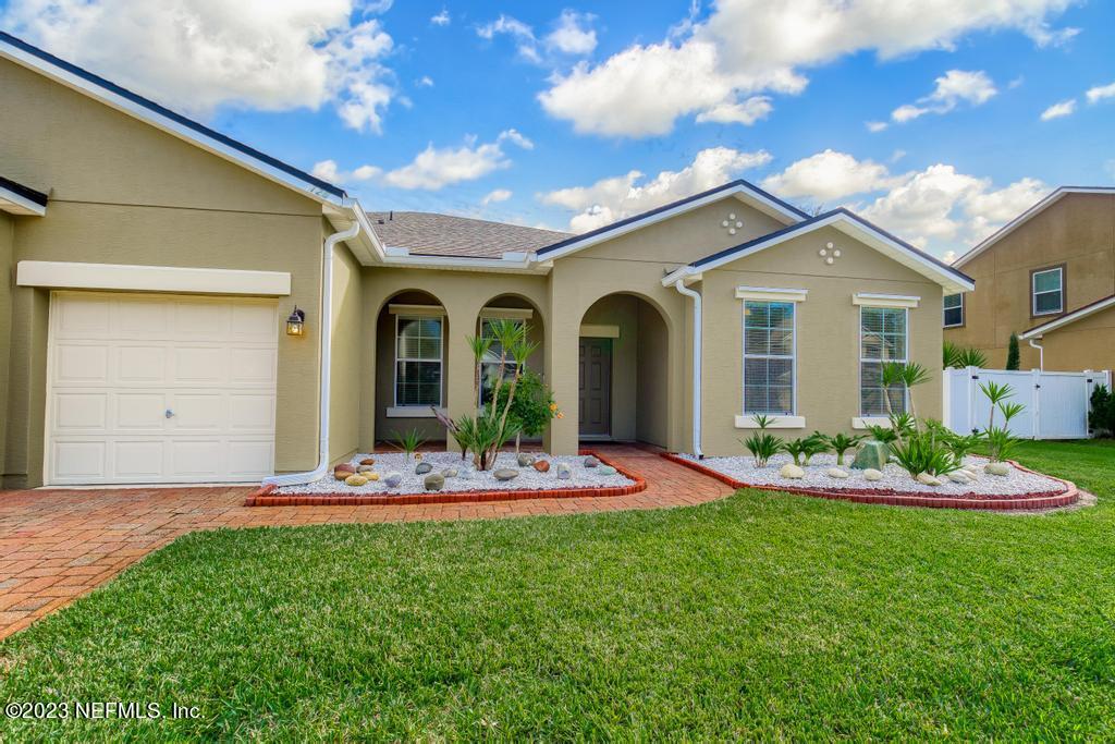 126 Arabian Court St. Augustine, FL 32095 - Photo 31 of 62 a front view of a house with a garden and plants