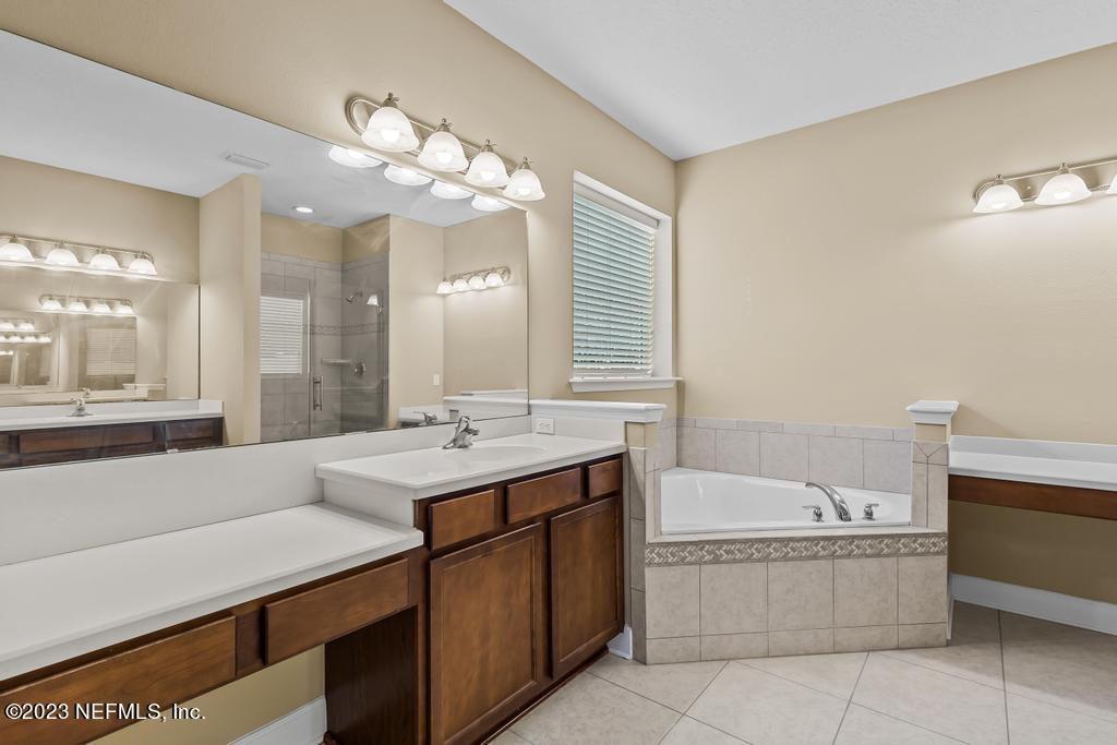 126 Arabian Court St. Augustine, FL 32095 - Photo 55 of 62 a bathroom with a bathtub a sink and a large mirror