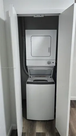 a utility room with wooden floor washer and dryer