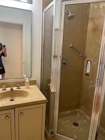 a bathroom with a shower sink and mirror
