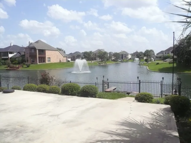 a front view of a house with a yard and lake view
