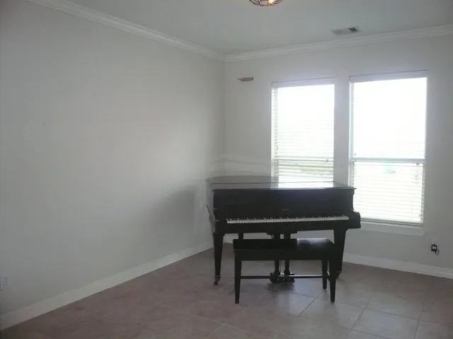 an empty room with chandelier fan and windows