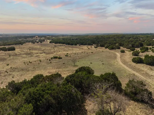 an aerial view of residential houses with outdoor space and trees