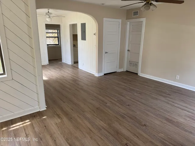 a view of a hallway with wooden floor and closet