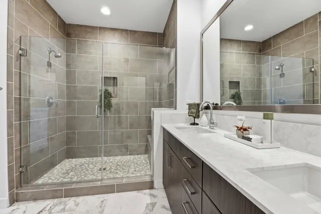 a bathroom with a shower sink and mirror