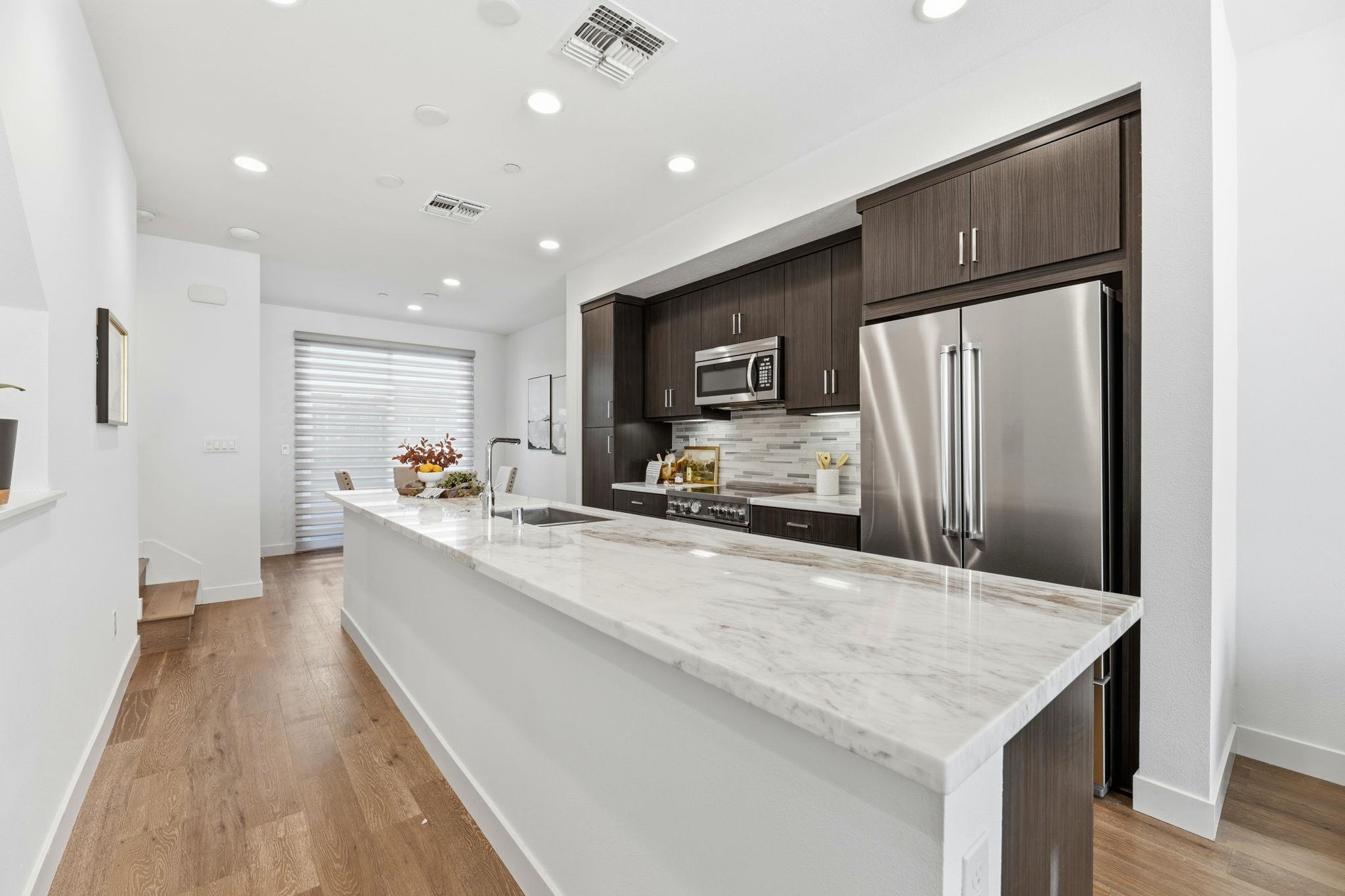 931 Edy Lane Oakland, CA 94607 - Photo 6 of 41 a large kitchen with kitchen island a large counter top stainless steel appliances and cabinets