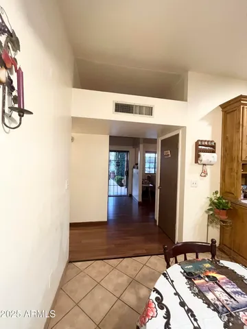 a kitchen with stainless steel appliances kitchen island granite countertop a stove a refrigerator a sink a dining table and chairs with wooden floor