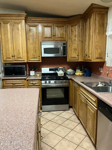 a kitchen with a stove a sink a microwave and a refrigerator