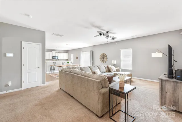 a living room with furniture a flat screen tv and a table