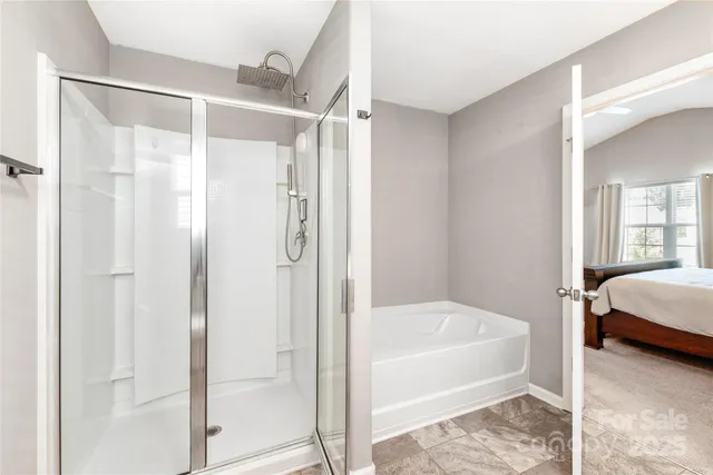a bathroom with a tub shower and hallway