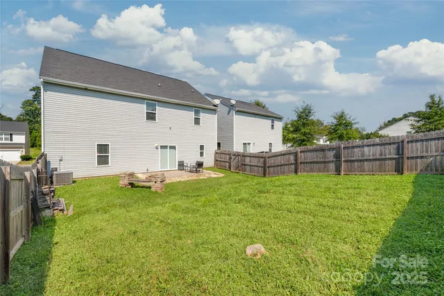 a view of backyard with wooden fence