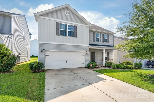 a front view of a house with a yard and trees