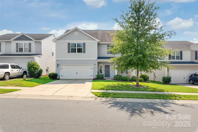 a front view of a house with a yard and trees