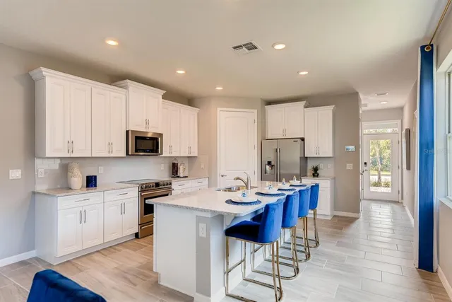a kitchen with stainless steel appliances kitchen island granite countertop a sink and cabinets