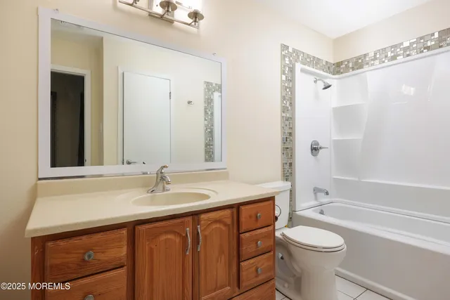 a bathroom with a sink a toilet a mirror a bathtub and shower