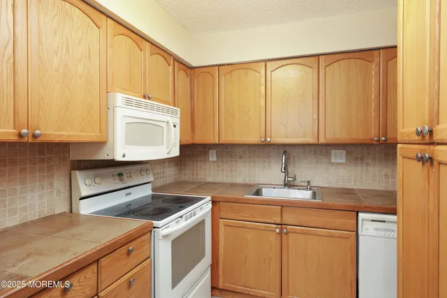 a kitchen with stainless steel appliances granite countertop white cabinets sink and a granite counter top