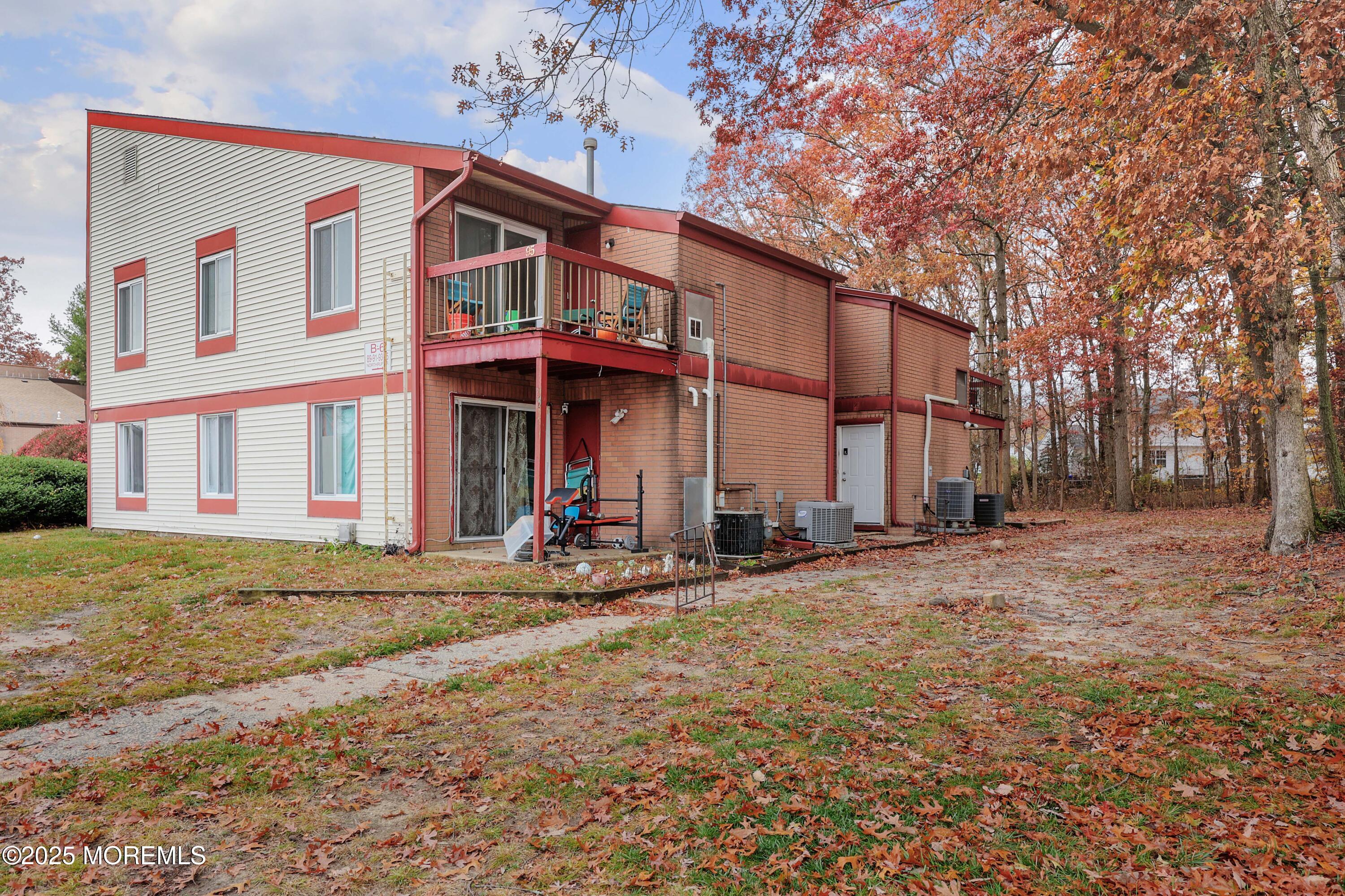 89 Northrup Drive, Unit 75 Brick, NJ 08724 - Photo 20 of 22 a view of a house with large windows and a tree