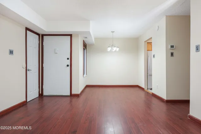 an empty room with wooden floor and a window