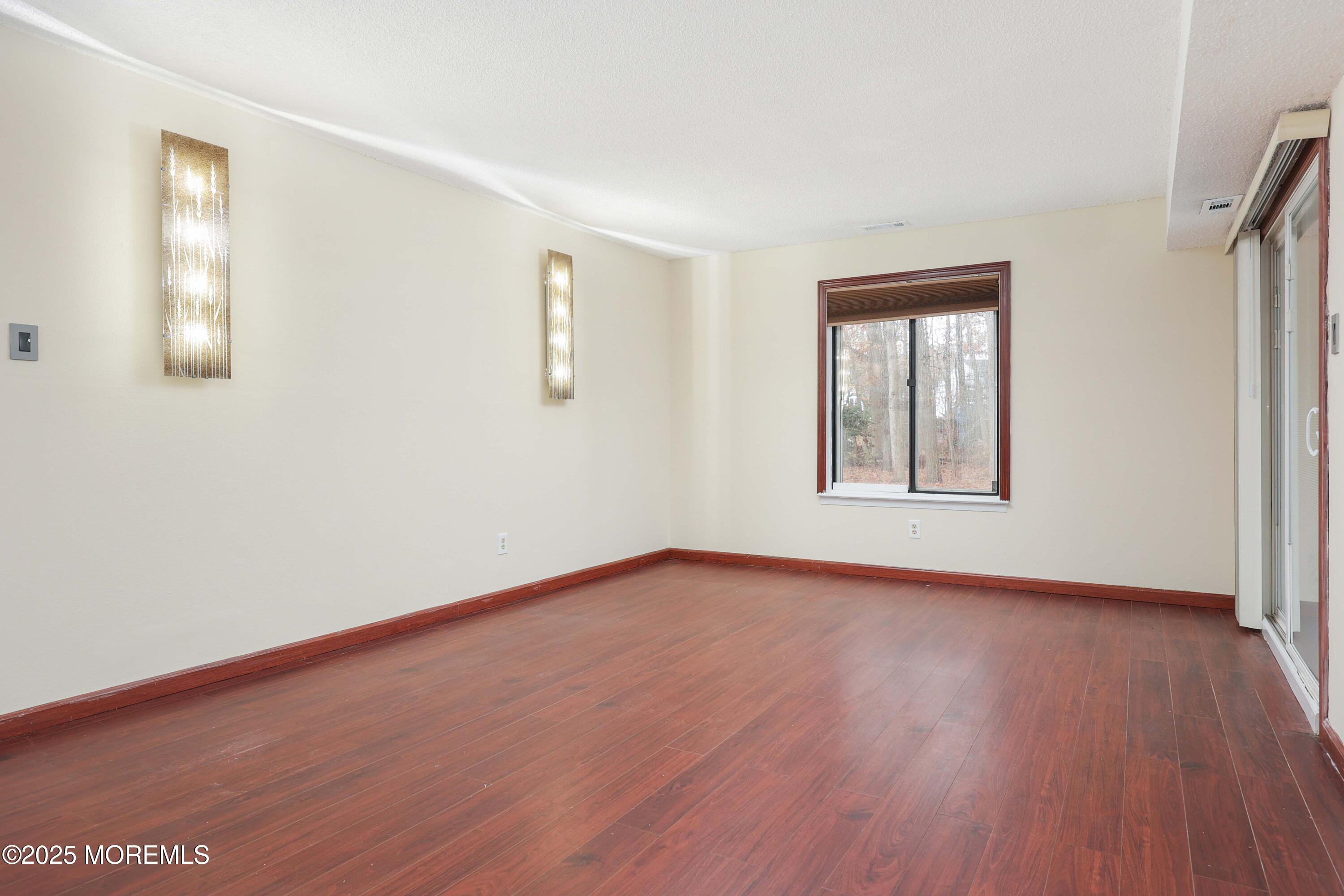 89 Northrup Drive, Unit 75 Brick, NJ 08724 - Photo 10 of 22 a view of an empty room with wooden floor and a window