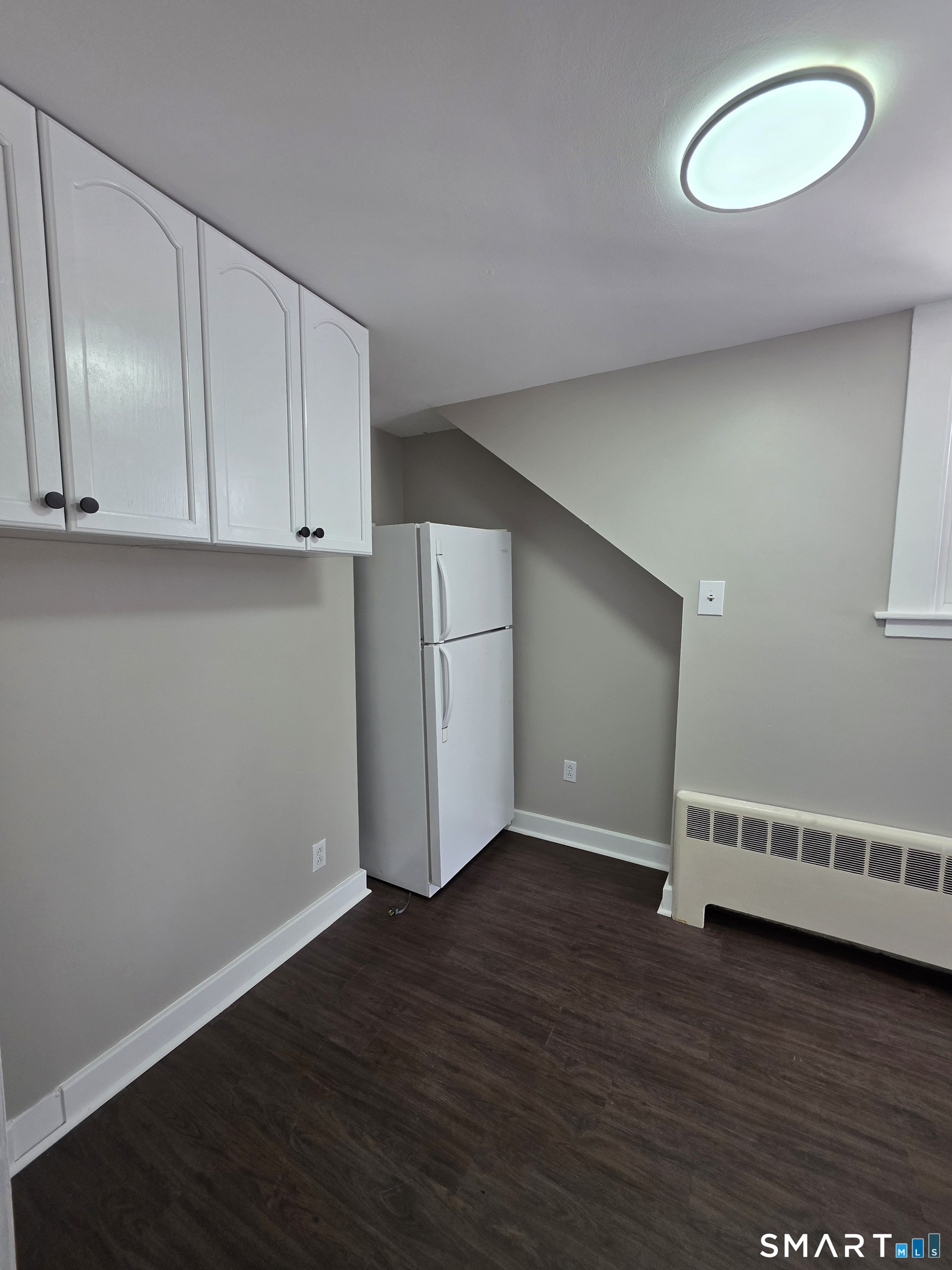 396 West Main Street, Unit 3 New Britain, CT 06052 - Photo 3 of 17 a view of an empty room with wooden floor and cabinet