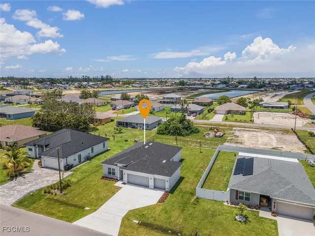 an aerial view of a house with a garden and lake view