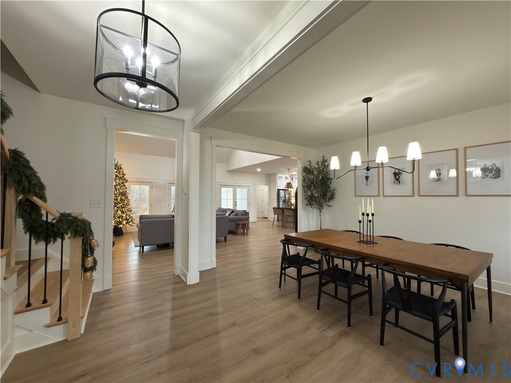 7017 Claiborne Road Sutherland, VA 23885 - Photo 19 of 62 a dining room with wooden floor a chandelier a wooden table and chairs