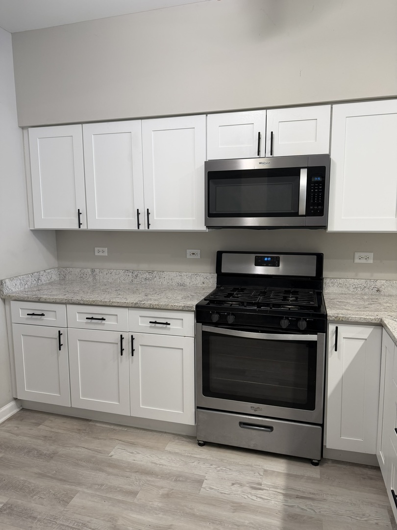 2522 Arcadia Circle Naperville, IL 60540 - Photo 4 of 18 a kitchen with granite countertop a stove and a microwave