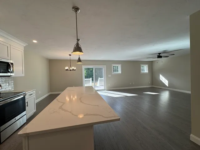 a kitchen with kitchen island a counter top a stove and a wooden floors