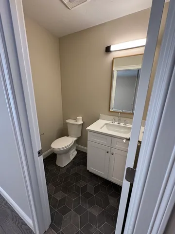 a bathroom with a toilet sink and a mirror