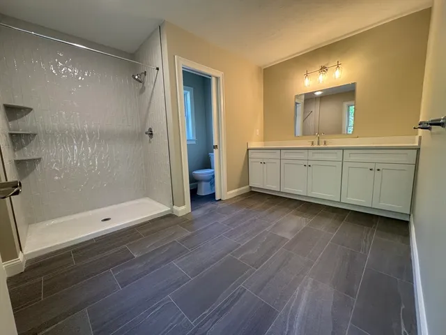 a bathroom with a glass door shower a sink and a mirror