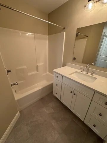 a spacious bathroom with a double vanity sink a mirror and a bathtub
