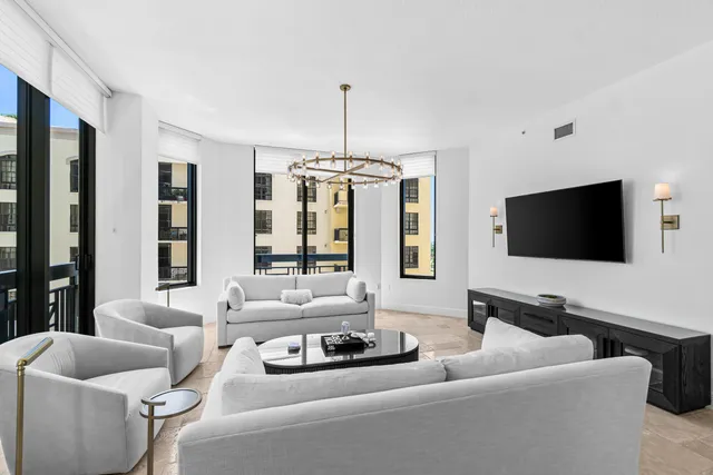 a living room with furniture a chandelier and a flat screen tv