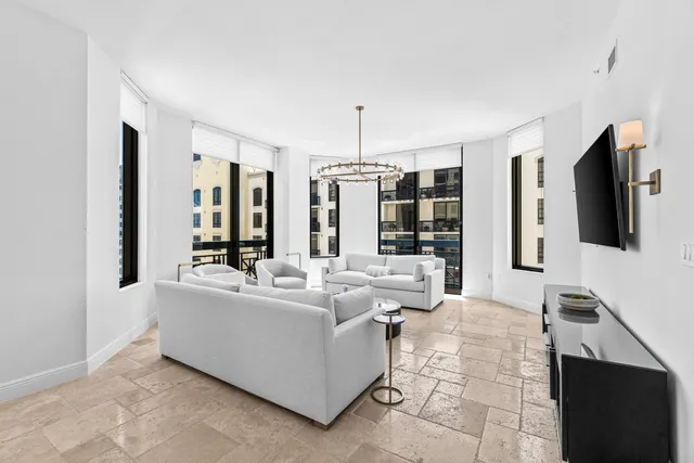 a living room with furniture and chandelier