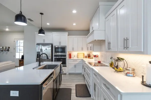 a kitchen with kitchen island a sink appliances and cabinets