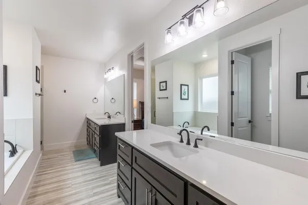 a spacious bathroom with a sink double vanity granite and a mirror