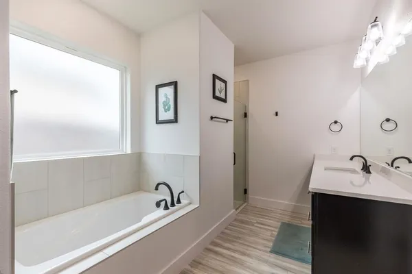 a bathroom with a tub a sink and mirrors