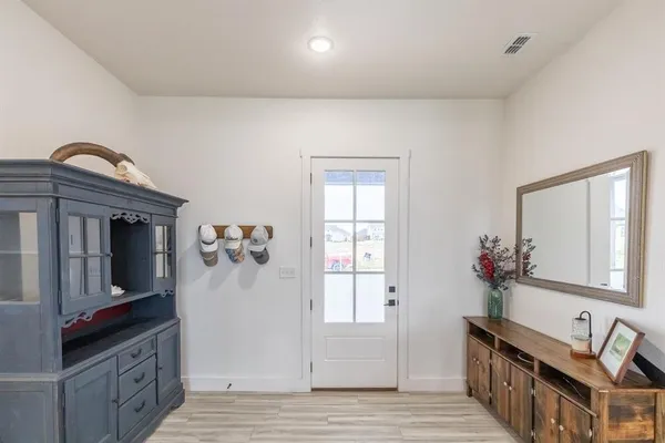 a view of a livingroom with wooden floor and a flat screen tv