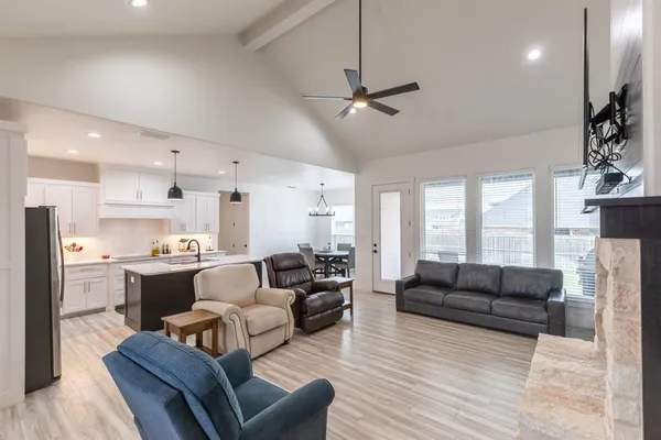 a living room with furniture kitchen view and a large window