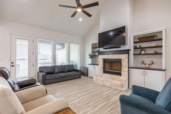 a living room with furniture a flat screen tv and a fireplace