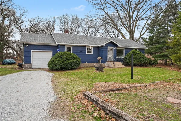 a front view of a house with a yard and trees