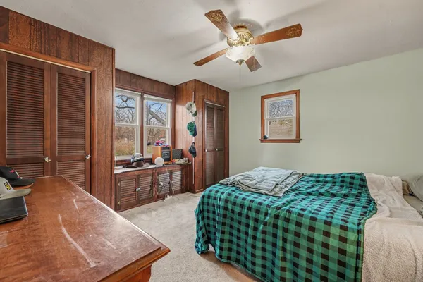 a bedroom with a large bed a chandelier and dresser