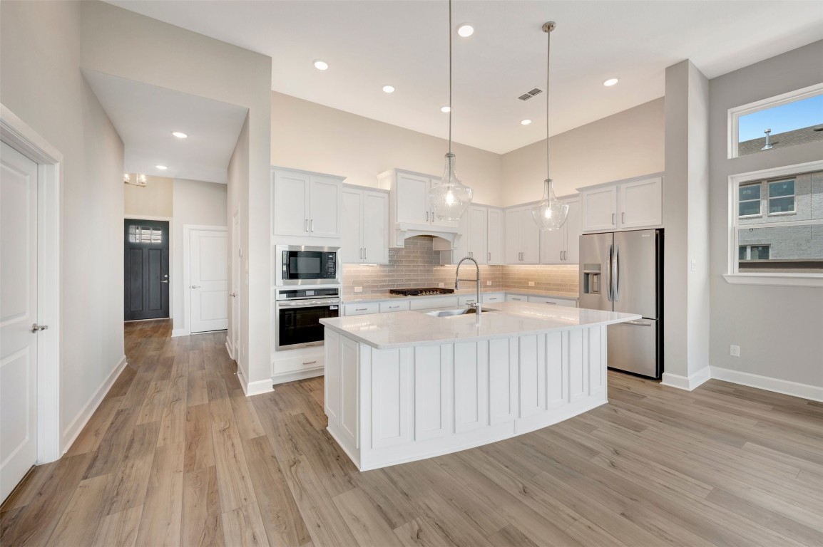 2423 Msn Hts Way Manvel, TX 77578 - Photo 25 of 49 an open kitchen with kitchen island and stainless steel appliances