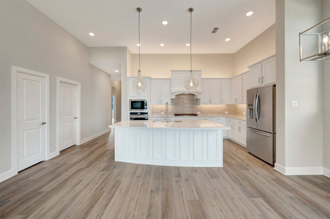 2423 Msn Hts Way Manvel, TX 77578 - Photo 26 of 49 a kitchen with stainless steel appliances a refrigerator a stove top oven and kitchen island