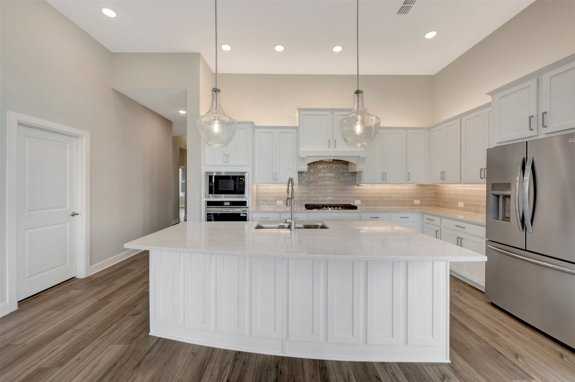 2423 Msn Hts Way Manvel, TX 77578 - Photo 27 of 49 a kitchen with kitchen island a sink stainless steel appliances and wooden floor