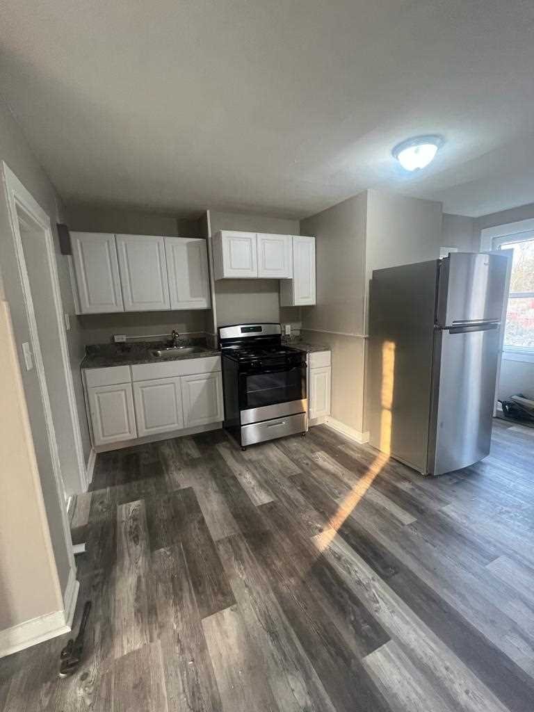24-26 Spring Street, Unit 2 Wappingers Falls, NY 12590 - Photo 3 of 7 a kitchen with a refrigerator and a stove top oven
