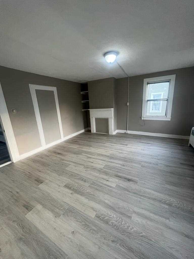 24-26 Spring Street, Unit 2 Wappingers Falls, NY 12590 - Photo 4 of 7 an empty room with wooden floor and windows